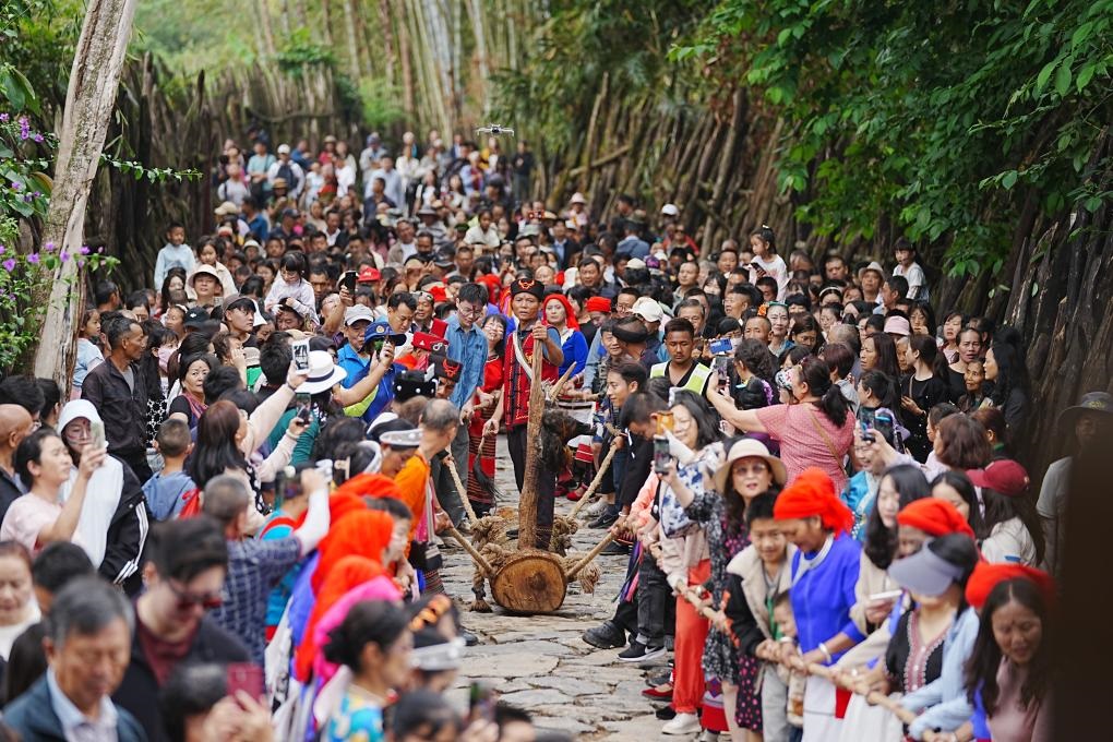 5月3日，各地游客在滄源縣翁丁村和村民一起參加佤族傳統(tǒng)民俗拉木鼓活動(dòng)。（滄源縣融媒體中心供圖）