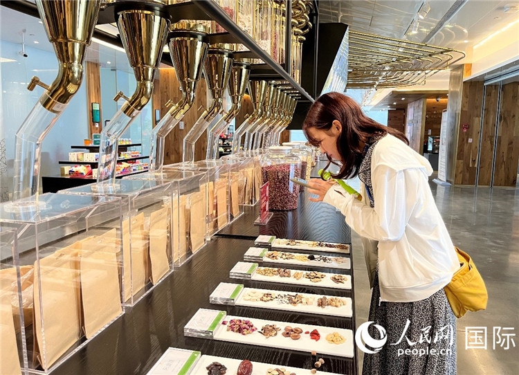 4. 代表團(tuán)團(tuán)員對(duì)新中式茶飲的食材充滿興趣。（人民網(wǎng)記者陳思 攝）