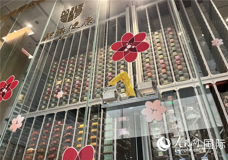 6. 機(jī)械臂正在取貨。（人民網(wǎng)記者陳思 攝）