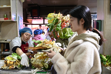 游客挑選好麻辣燙菜品后排隊(duì)等待加工。新華社記者 范培珅 攝