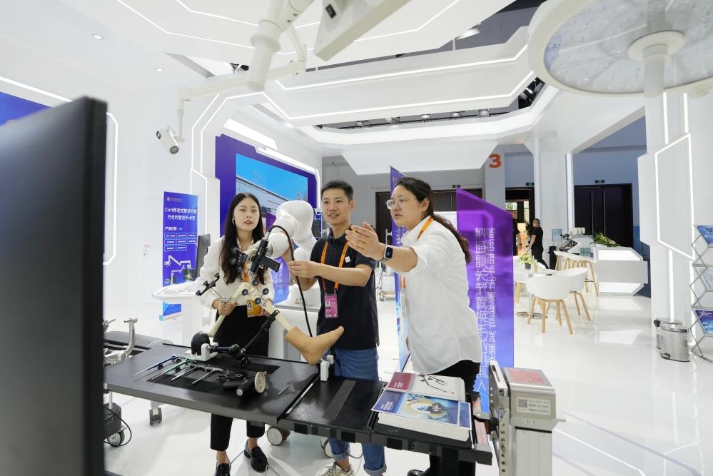 9月11日，一位媒體記者（中）在2024年服貿(mào)會(huì)國(guó)家會(huì)議中心會(huì)場(chǎng)體驗(yàn)北京納通科技集團(tuán)有限公司的膝關(guān)節(jié)置換手術(shù)機(jī)器人。新華社記者鞠煥宗 攝