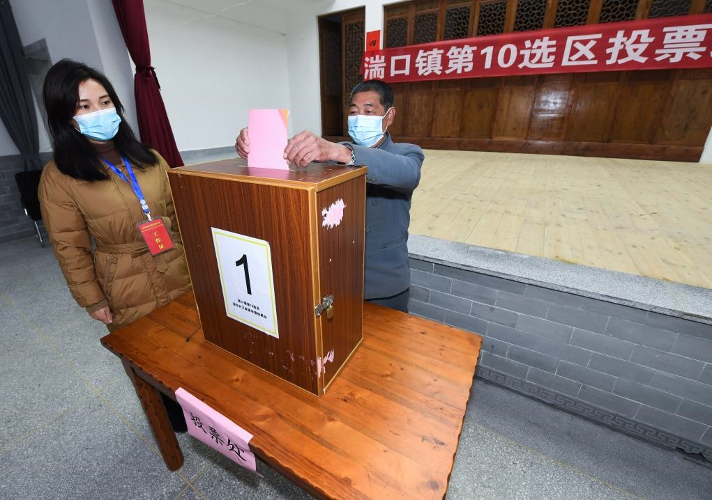 2021年12月14日，在浙江省杭州市臨安區(qū)湍口鎮(zhèn)迎豐村的基層投票點(diǎn)，村民在參加投票，村級監(jiān)察聯(lián)絡(luò)員監(jiān)票。新華社記者 徐昱 攝