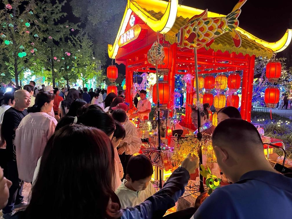 市民游客在2024年北京中秋國(guó)慶彩燈游園會(huì)上選購(gòu)特色文創(chuàng)商品。新華社記者楊淑君 攝