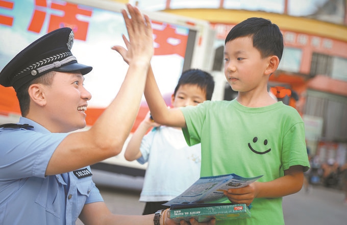 ▲7月10日，江西省吉安市公安局吉州分局組織民警深入轄區(qū)開展安全宣傳，民警向小朋友講解防溺水知識(shí)。朱文杰攝