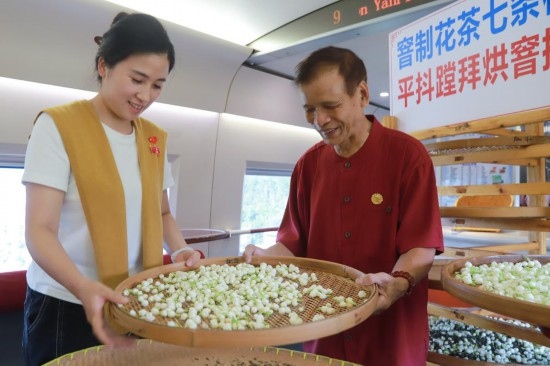10月1日，福州市茉莉花茶窨制工藝代表性傳承人張子建與旅客在G1634次列車(chē)上制作茉莉花茶。新華社記者周義 攝