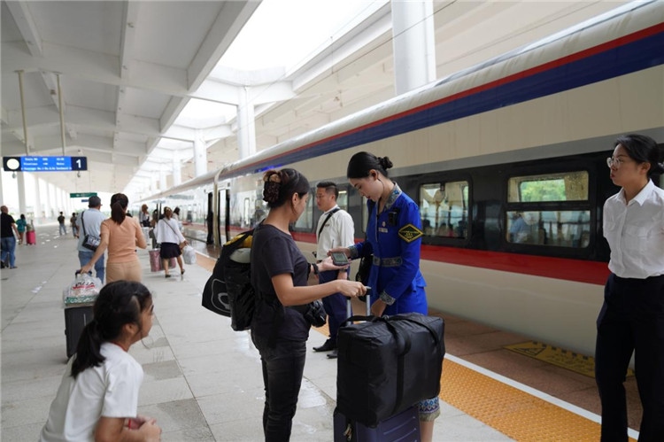 中老鐵路工作人員在站臺指引旅客進站乘車。老中鐵路有限公司供圖