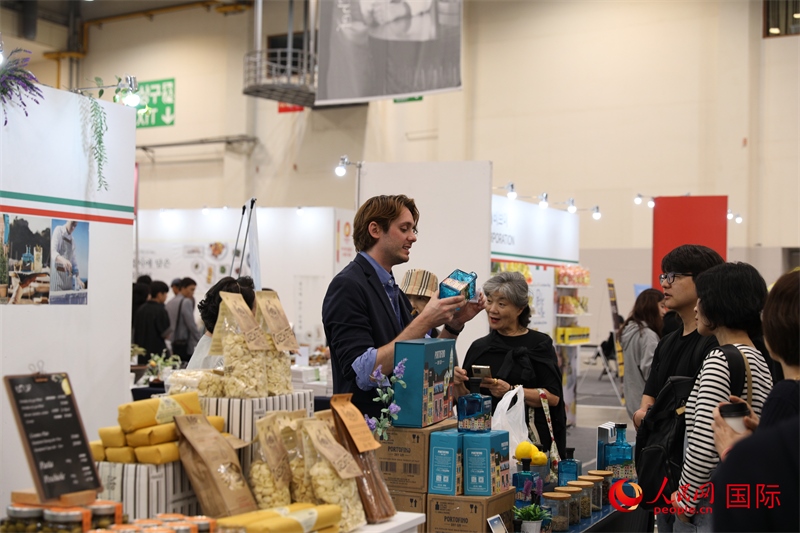 當(dāng)?shù)貢r(shí)間10月5日，在第21屆釜山國(guó)際美食博覽會(huì)上，意大利展商向參觀者們介紹的意大利食品。人民網(wǎng)記者 莽九晨攝