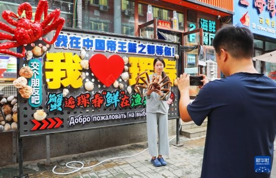 9月21日，游客在吉林省琿春市一處帝王蟹元素主題裝飾前拍照留念。新華社發(fā)