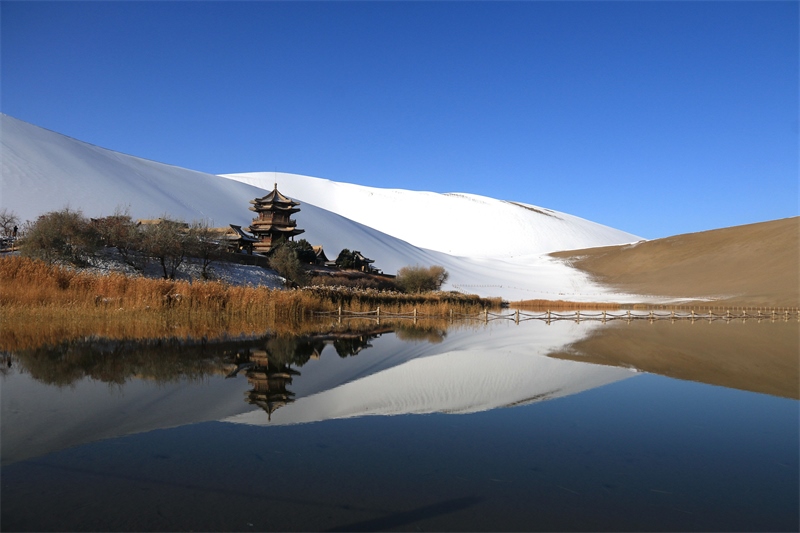 鳴沙山月牙泉景區(qū)雪景。敦煌市委宣傳部供圖，張曉亮攝