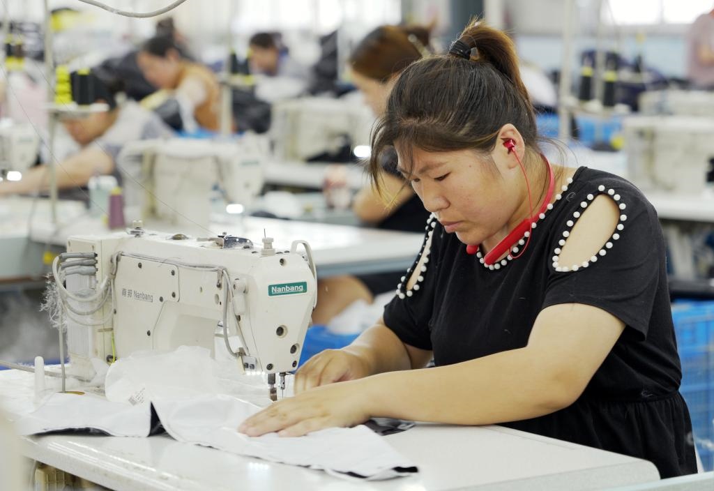 5月20日，村民在李寨村服裝加工廠內(nèi)忙碌。河南省周口市沈丘縣馮營鎮(zhèn)李寨村地處豫東平原。近年來，乘著脫貧攻堅與鄉(xiāng)村振興政策的東風，李寨村積極探索產(chǎn)業(yè)發(fā)展模式，通過“龍頭企業(yè)+村集體經(jīng)濟+農(nóng)戶”的方式，逐漸發(fā)展形成肉牛養(yǎng)殖、設(shè)施農(nóng)業(yè)、服裝加工、康養(yǎng)民宿等產(chǎn)業(yè)，以產(chǎn)業(yè)振興助力鄉(xiāng)村振興。新華社記者 李嘉南 攝