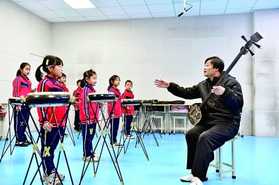 圖為12月30日，在惠民縣胡集鎮(zhèn)第一小學(xué)，老師指導(dǎo)學(xué)生學(xué)習(xí)西河大鼓。新華社記者 郭緒雷攝