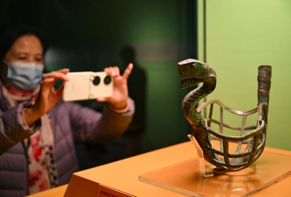 1月14日，觀眾在上海博物館蛇年迎春展拍攝展品蛇綱網(wǎng)狀銅器。新華社發(fā)（陳浩明攝）