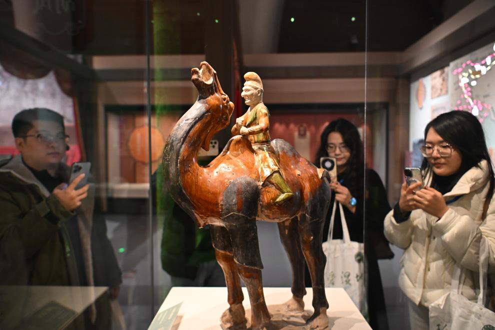 1月15日，觀眾在拍攝“長安三萬里——陜西唐代文物精華展”展出的三彩胡人騎駝俑。（新華社記者 孫凡越 攝）