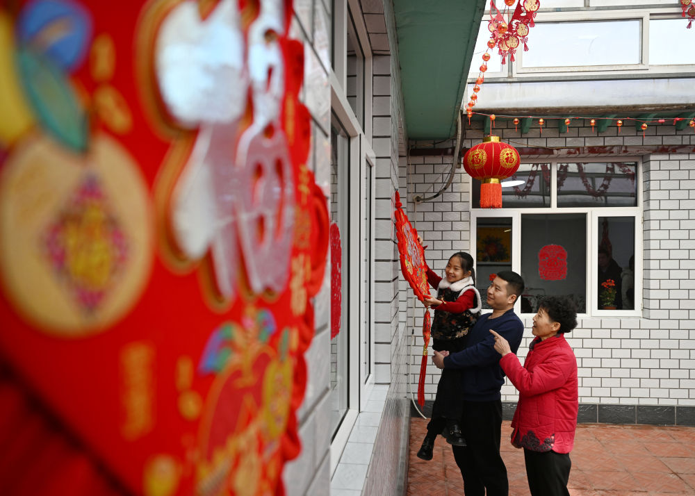 天津市西青區(qū)辛口鎮(zhèn)第六埠村村民在院子里掛“福”字（2024年2月1日攝）。新華社記者 趙子碩 攝