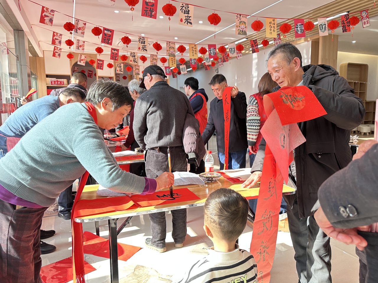 今年春節(jié)前夕，慶元縣濛洲街道同濟(jì)新村，一場(chǎng)送春聯(lián)活動(dòng)熱鬧舉行。慶元縣融媒體中心 供圖
