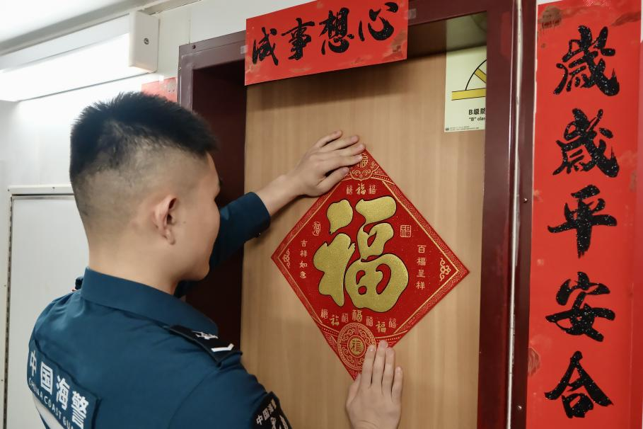 1月27日，在中國(guó)海警海鷗艦上，執(zhí)法員貼春聯(lián)福字慶祝農(nóng)歷春節(jié)。