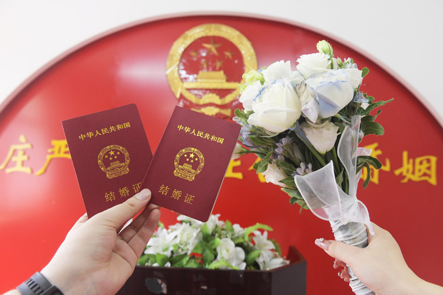 2024年8月10日，一對新人在河北石家莊新樂市民政局婚姻登記處領(lǐng)取結(jié)婚證后拍照留念。新華社發(fā)（賈敏杰攝）
