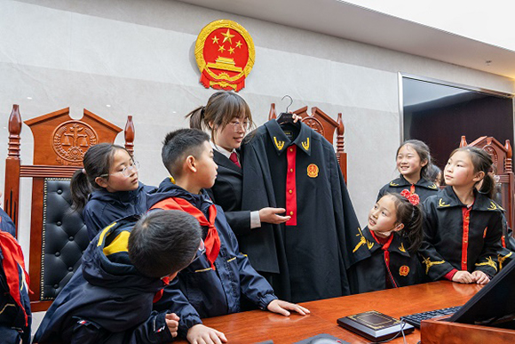 圖②：干警向同學們介紹法袍。