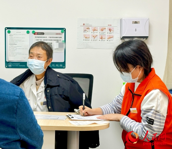 秦苑（中）接診患者。人民網(wǎng)記者 金慧慧攝