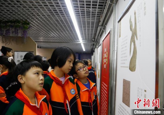 圖為學(xué)生參觀青海省博物館“1+3”主題流動展覽，了解木舞俑。中新社記者 馬銘言 攝