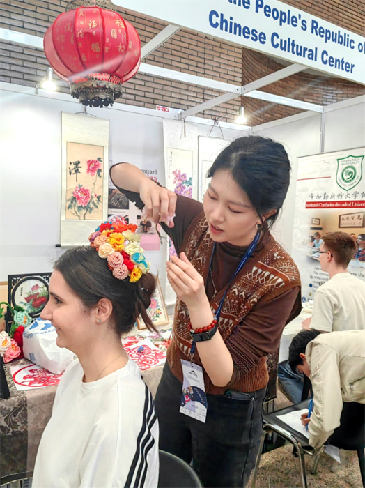 展覽正值羅馬尼亞迎春花節(jié)，國際中文教師志愿者潘婧穎向游客們介紹了國家非物質(zhì)文化遺產(chǎn)——福建泉州的簪花文化。布加勒斯特大學(xué)孔子學(xué)院供圖。