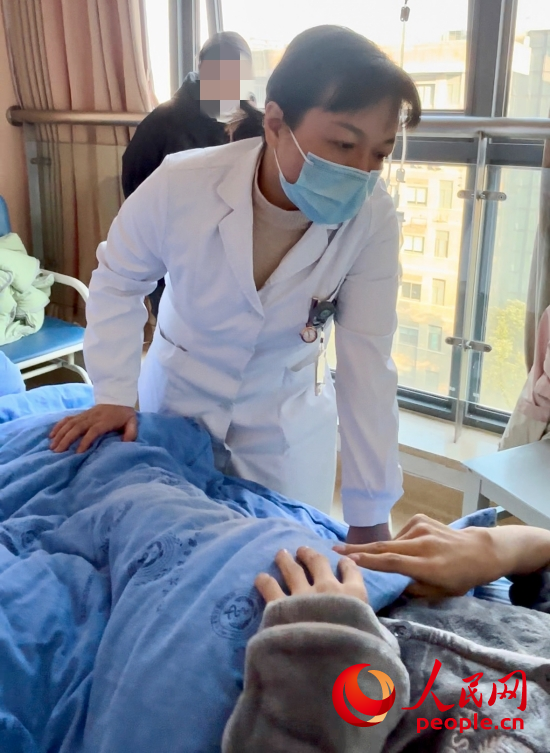 鄧茜查房時詢問患者情況。人民網(wǎng)記者 金慧慧攝