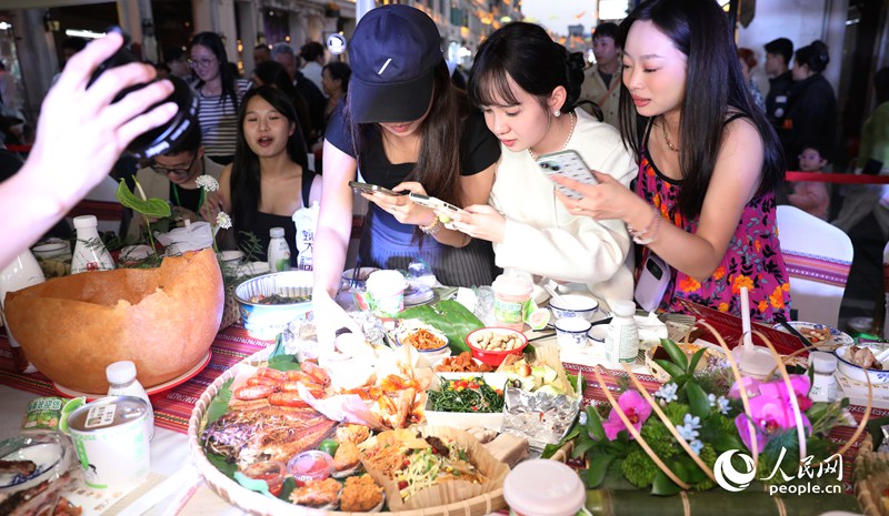 游客拍照打卡體驗(yàn)長(zhǎng)桌宴。人民網(wǎng)記者 符武平攝
