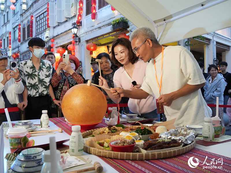 嘉賓品嘗海南傳統(tǒng)美食“煎堆”。人民網(wǎng)記者 張力洋攝