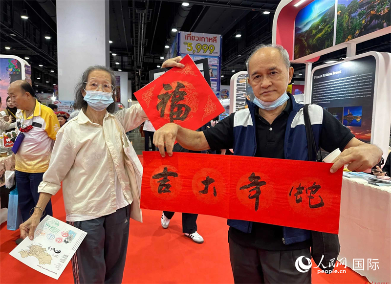 2025蛇年春節(jié)，泰國市民展示他們領(lǐng)到的華人手寫春聯(lián)。人民網(wǎng)記者 簡承淵攝