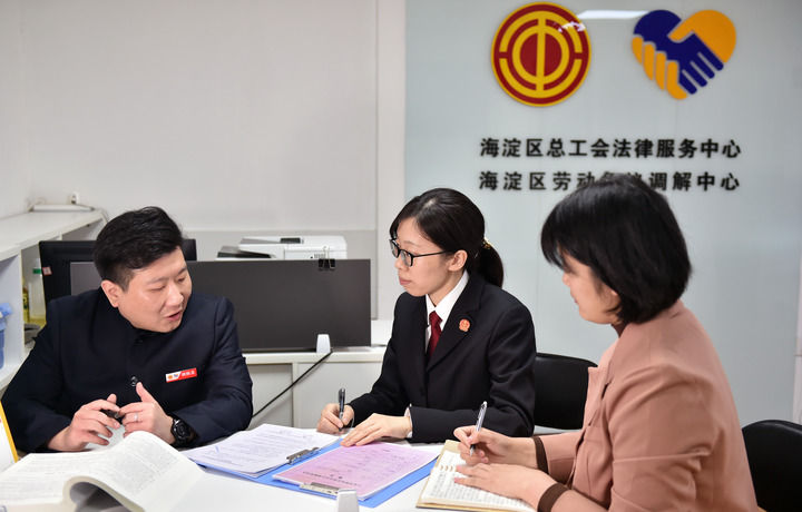 2025年3月6日，在北京市海淀區(qū)總工會勞動爭議調(diào)解中心，海淀區(qū)人民法院法官王琰（中）與該中心工作人員就糾紛化解情況進行溝通。新華社記者 趙婷婷 攝