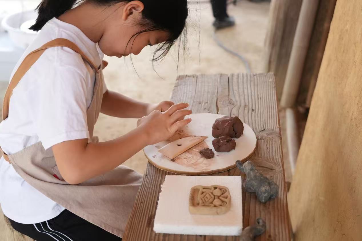 游客制作良渚特色陶藝品。良渚博物院供圖