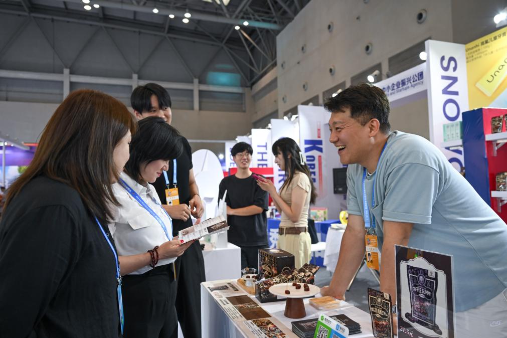 5月22日，韓國(guó)展商（右一）在西洽會(huì)現(xiàn)場(chǎng)向參觀者介紹產(chǎn)品。新華社記者 陳誠(chéng) 攝