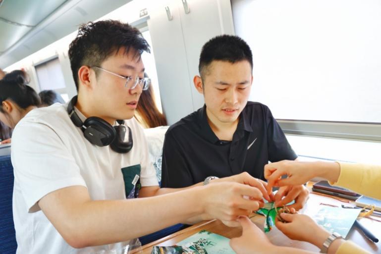G232次旅客親手制作端午荷包和五彩繩。王磊攝